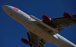 The Virgin Orbit 'Cosmic Girl' -- a modified Boeing 747 carrying a LauncherOne rocket under its wing -- takes off from Mojave Air and Space Port in 2021