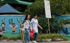 Women walk outside the preschool where an attacker killed four children in Blumenau in   southern Brazil