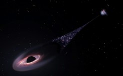 A supermassive black hole - seen here in an artist's impression - is forging a contrail of newborn heavenly bodies