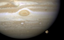 The moon Ganymede lurks behind the gas giant Jupiter in a Hubble telescope image from 2008