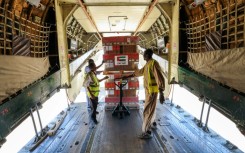 Workers offload WHO and UAEAID aid supplies from a plane in Port Sudan