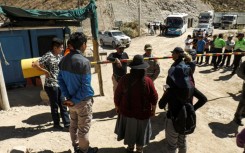 Relatives of miners wait for information at the entrance of the La Esperanza mine, where at least 27 people died following a fire