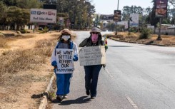 Dangarembga (L) and colleague Julie Barnes hold placards during their 2020 anti-corruption protest in Harare