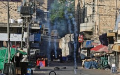 Israeli security forces fire tear gas to disperse Palestinians during a raid in the occupied West Bank city of Nablus