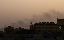 Smoke billows behind buildings in southern Khartoum -- mediators say both warring sides have violated the week-long truce