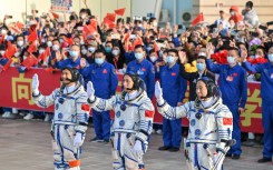 Gui Haichao (L) payload expert, Zhu Yangzhu (C) space flight engineer and commander Jing Haipeng (R) wave during the seeing-off ceremony for the Shenzhou-16 mission to China's space station