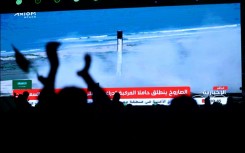 People watch a screen in Riyadh as a SpaceX Falcon 9 rocket carrying the Axiom Mission 2 astronauts lifts off from pad 39A at NASA's Kennedy Space Center in Florida