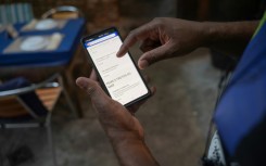 A worker shows a digital menu at Casa Nossa restaurant in the Lapa neighborhood in Rio de Janeiro, Brazil in May 2023.