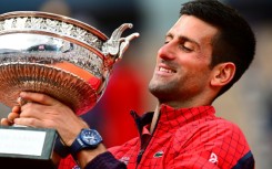 Record-breaker: Novak Djokovic poses with his trophy on Sunday