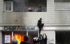 A protester climbs on a building during clashes in Nanterre on Thursday