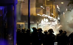 Fireworks explode as police stand by during protests in the northern city of Roubaix