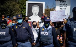 File: Community members hold a placard with an image of Nathaniel Julies in Eldorado Park. AFP/Michele Spatari