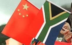 File: Members of the Chinese community wave Chinese and South African flags. AFP/Anna Zieminski