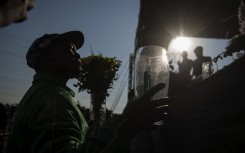 A mine worker holds a candle during a ceremony marking the third anniversary of the Marikana massacre of 34 striking platinum miners, near Rustenburg, on August 16, 2015.