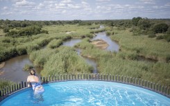 File: A guest overlooks the landscape from a suspended pool at the Kruger Shalati hotel in Skukuza. AFP/Michele Spatari