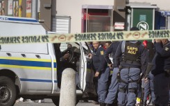 File: Police officers at the scene of a murder of an alleged gang member. AFP/Rodger Bosch