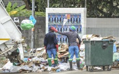 File: Workers prepare to load garbage into a truck. AFP