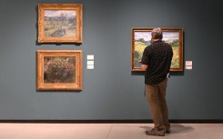 A visitor looks at a painting by Vincent van Gogh (R) next to paintings by Claude Monet and Camille Pissarro. AFP/Michal Cizek