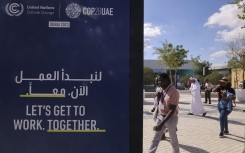 People arrive at the venue of the COP28 United Nations climate summit in Dubai. AFP/Karim Sahib