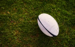 File: A rugby ball on an empty rugby field. GettyImages/PeopleImages