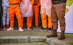 File: Prisoners standing next to a Correctional Services guard. Sharon Seretlo/Gallo Images via Getty Images