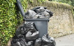 File: A full wheelie bin with rubbish bags overflowing. GettyImages/georgeclerk