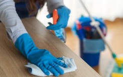 File: A domestic worker cleaning a desk. GettyImages/Dusan Sapic