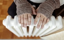 File: A man heats his hands over a heater. GettyImages/Jelena Stanojkovic