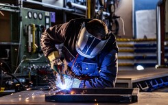 File: An industrial worker welding at the factory. Manufacturing sector. GettyImages/chriss_ns