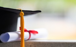 File: Close-up of a mortarboard and degree certificate. GettyImages/sengchoy