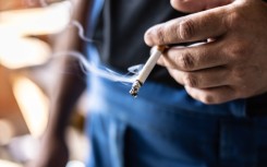 File: A man holding a smoking cigarette in his hand. GettyImages/SimpleImages