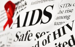 File: A red awareness ribbon on AIDS-related newspaper headlines. GettyImages/RapidEye