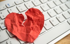 File: A broken heart paper on white keyboard computer background. GettyImages/Pla2na