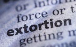 The word extortion in a dictionary. GettyImages/JLGutierrez