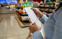 File: A shopper checking her receipt. GettyImages/Hispanolistic