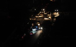 File: Vehicles travel along a darkened street without lighting. Leon Sadiki/Bloomberg via Getty Images