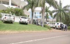 Officials outside Shauwn Mkhize's Durban mansion. 