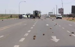 Police vehicles at a protest in Lenasia.