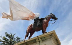 The statue of Rhodes on a horse was covered in red with a white cloth over his face. Supplied