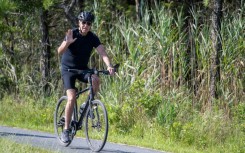 President Joe Biden, vacationing in Rehoboth Beach, Delaware, remained silent as he rode his bike past reporters who asked questions about his rival Donald Trump's legal woes