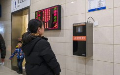 An automatic toilet paper dispenser (R) at a Chinese railway station uses facial recognition technology. China is drafting rules on use of the technology