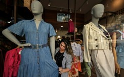 A saleswoman dresses a plus size mannequin at a store in Sao Paulo, Brazil