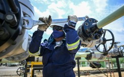 A worker fixes a pipeline at an oil facility in the town of Acacias in Colombia in February 2023