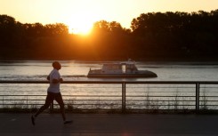 A man jogs along the docks at sunrise to avoid the heat, in Bordeaux, southwestern France.