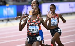 Kenya's Faith Kipyegon (C) reacts as she crosses the finish line to win the women's 5000m final ahead of Netherlands' Sifan Hassan (L) and Kenya's Beatrice Chebet (R)