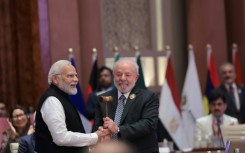 India's Prime Minister Narendra Modi (L) hands over the gavel to Brazil's President Luiz Inacio Lula da Silva (R) and the end of the G20 summit