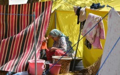 A woman sits outside her tent at a camp for locals displaced by a devastating earthquake in Amizmiz on September 16, 2023