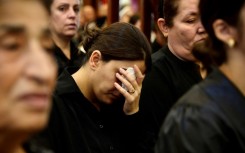 Iraqi mourners attend a mass for the victims of a wedding hall fire at a church in Qaraqosh