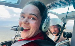 This handout photo dated July 13, 2022, shows firefighter Kara Galbraith (L), in a helicopter Carmacks, Yukon, Canada, flying to a fire. Galbraith was deployed with an Initial Attack Crew to help with the fires in the Yukon