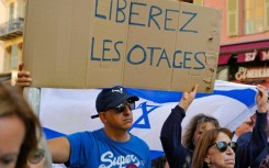 A demonstrator holds a placard reading "Free the hostages" during a rally in support of the people of Israel on the French riviera city of Nice